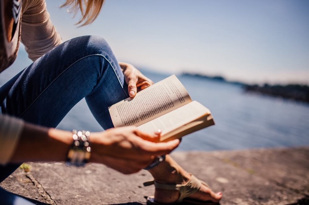 海辺で本を読む女性