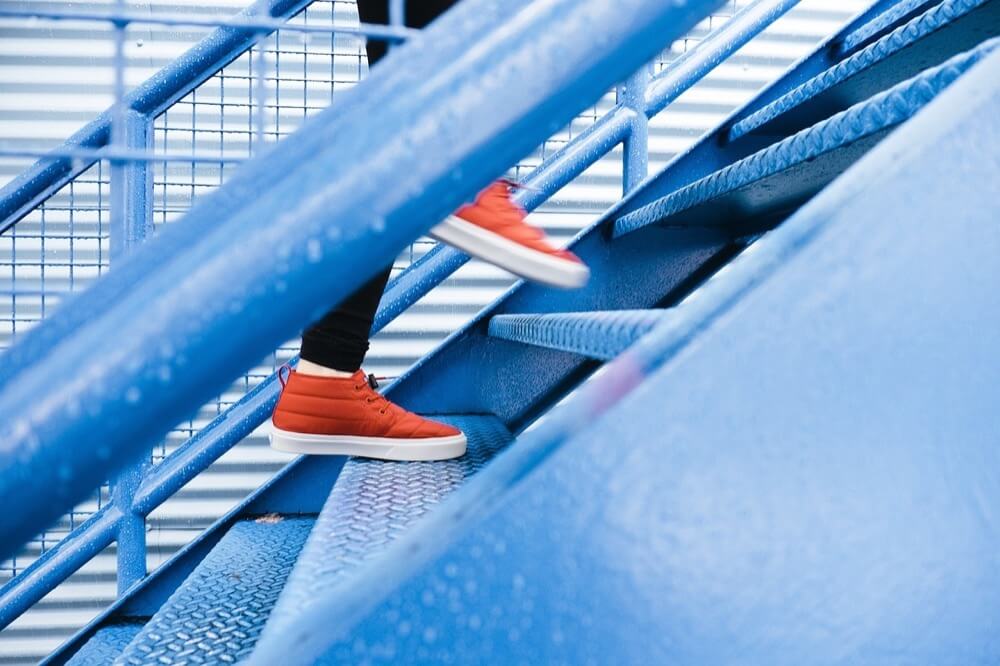 青い階段を登る人